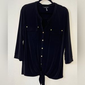 Black blouse with gold button detail has stretch